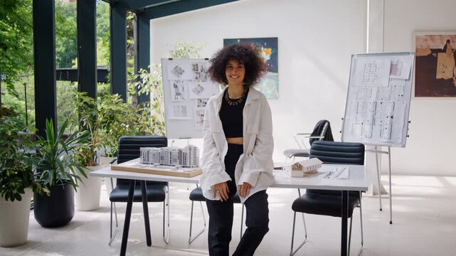 African American female designer with kinky hair sits on desk