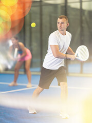 Fototapeta premium Padel game - girl with partners plays on the tennis court