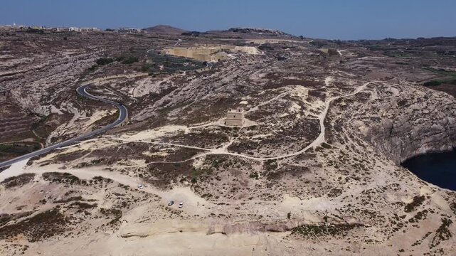 Aerial view of Dwerja bay in Gozo at noon with clear skies and rock formations brown and gray earth tones and natural beauty for nature documentarie. High quality 4k footage