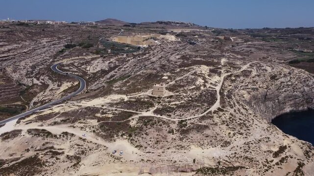Aerial view of Dwerja bay in Gozo at noon with clear skies and rock formations brown and gray earth tones and natural beauty for nature documentarie. High quality 4k footage