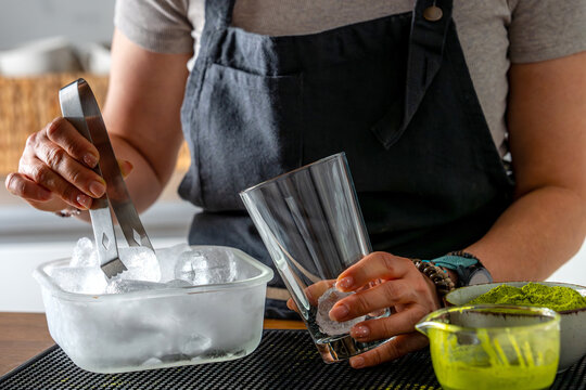 Woman Putting Ice In Glass
