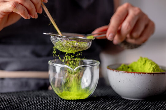 Woman Sieving Green Matcha Tea
