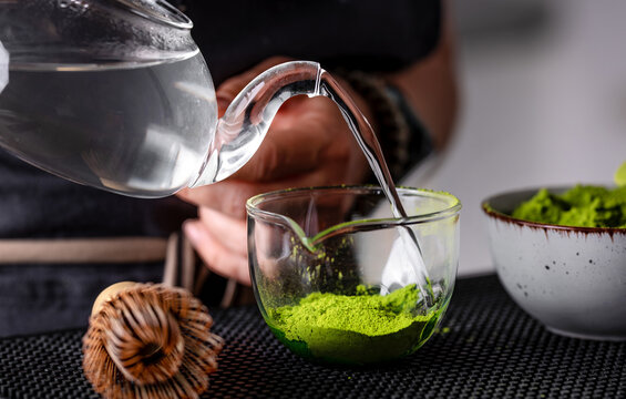 Woman Pouring Hot Water Into Green Matcha Tea
