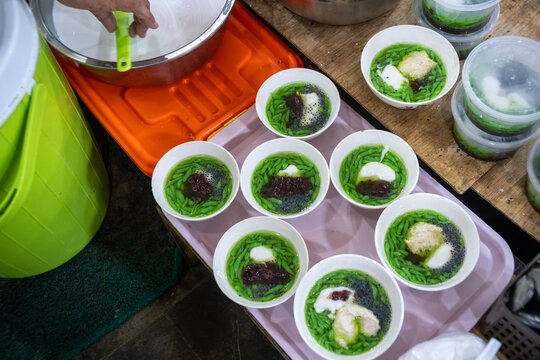 A high-angle close-up of bowls of traditional Javanese iced dessert (es dawet) arranged on a tray at a food stall in Pasar Gede, Solo, Indonesia.