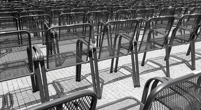 Rows of empty metal chairs creating a repetitive pattern