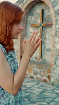 An Italian woman prays for forgiveness before a Christian crucifix at calvary
