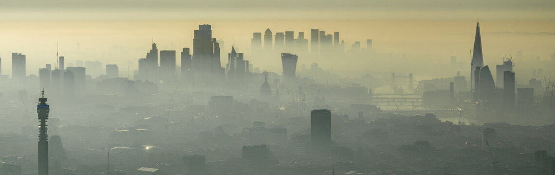 Aerial view of the London skyline shrouded in morning mist, featuring the Shard and BT Tower rising above the urban landscape in London, Greater London, United Kingdom.