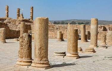 Obraz premium Remains of ancient weathered stone columns rising from mosaic floors at ruins of Grand Baths of Sufetula on sunny spring day, Tunisia