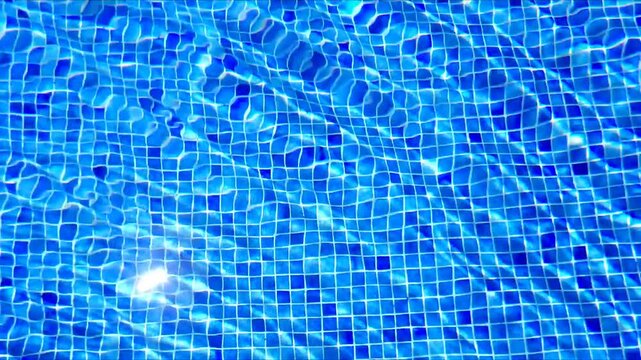 Ripples on water in sunlight over bright blue tile mosaic bottom at swimming pool
