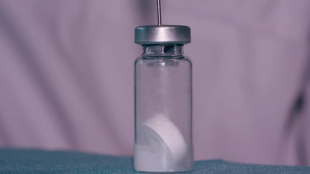 Medication, vial, dissolving, preparation: Close-up of dissolving powder in a pharmaceutical container