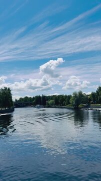 Sungai yang tenang dan langit yang cerah terabadikan dalam suasana alam terbuka yang damai.