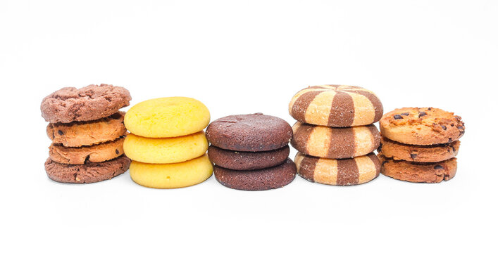 Pile of assorted cookies and biscuits isolated on white background. Collection of sweet baked snacks including chocolate cookies, butter biscuits, crackers and sandwich cookies.