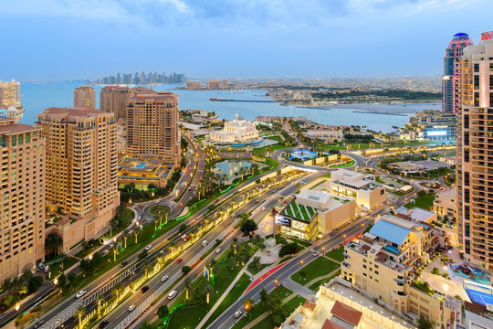 Twilight view of the Doha skyline with the Doha Pearl island and Sheikh Hamad bin Jassim Mosque in view along the Persian Gulf in Doha Qatar.