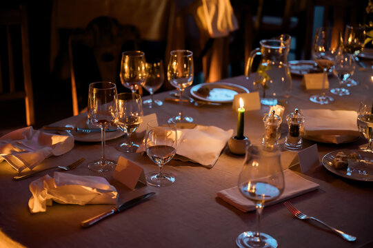 Refined candlelit dining table prepared for elegant wedding reception featuring crystal glassware linen napkins and sophisticated evening hospitality details