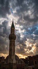 Obraz premium Islamic mosque minaret against dramatic sunset sky
