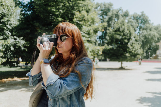 Woman Taking Photo Using Vintage Camera in Park