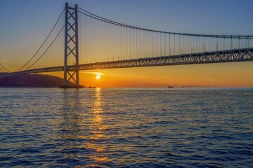 Obraz premium 夕日に映える明石海峡大橋と瀬戸内海の美しい夕暮れ風景