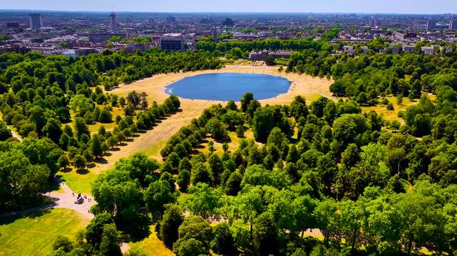 Aerial view of Round Pond in Hyde Park, London, framed by parkland on a sunny summer day; ideal for travel promotion, tourism, editorial, and urban design use