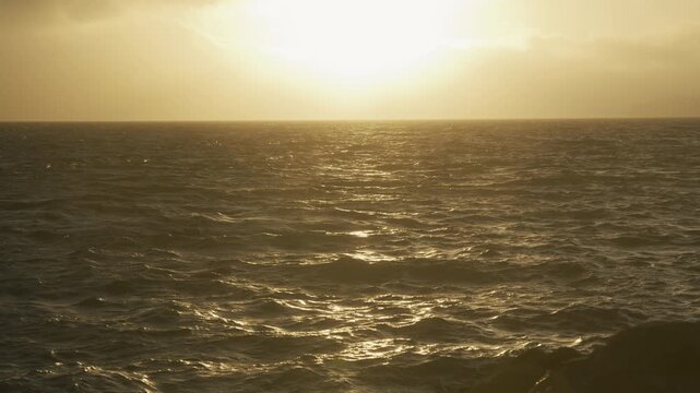 Open Ocean Choppy Waves With Golden Sun Glare On Horizon - Wide Shot