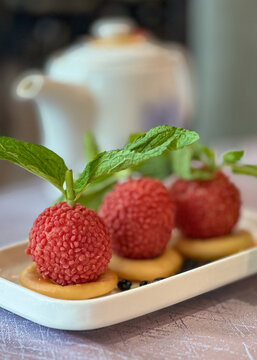 Delicate lychee dessert with mint and biscuit served on a white plate