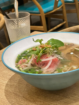 Authentic Vietnamese beef pho soup with fresh herbs and thinly sliced raw beef