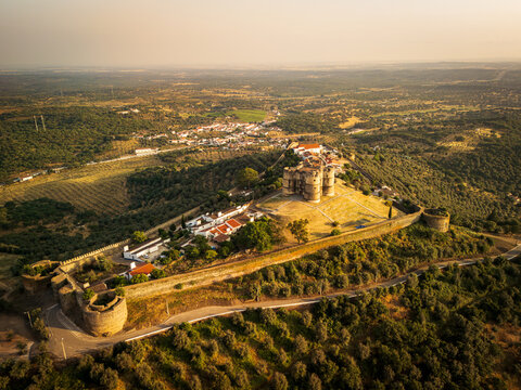 Aerial view of Evoramonte Castle perched on a hilltop surrounded by olive groves and rolling countryside in Evoramonte, Portugal.