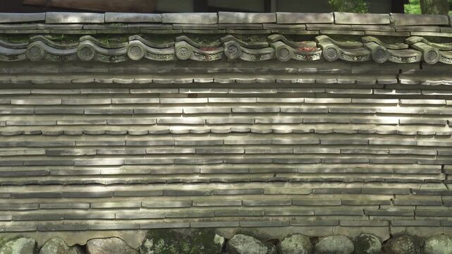 美しい木漏れ日が差し込む伝統的な瓦組みの築地塀 シンメトリー構図（音声なし）