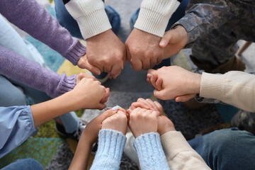 Obraz premium People holding hands at group therapy session, closeup