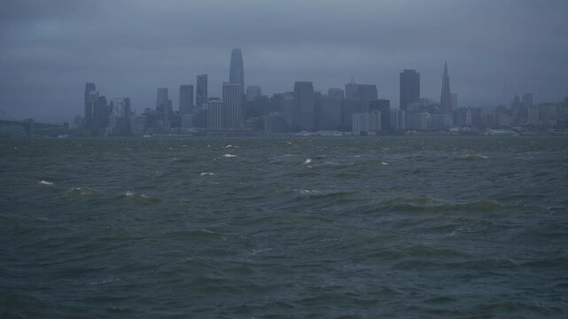 San Francisco Skyline Bay View With Choppy Waves In Foreground And Stormy, Overcast Sky
