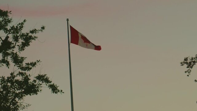 National flag of Canada waving on flagpole at sunset with copy space