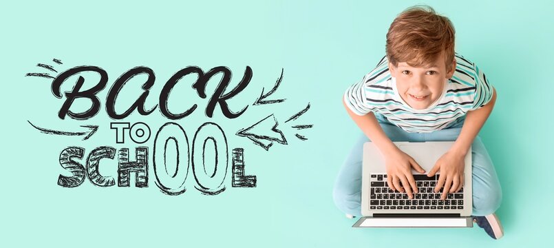 Smiling boy using laptop with back to school text