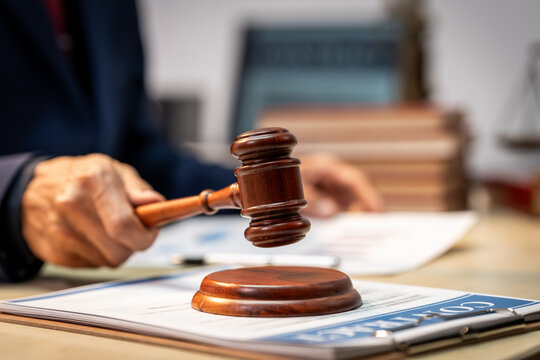 Close-up of a judge's gavel on paperwork with blurred legal office background, symbolizing law, justice, and court decisions