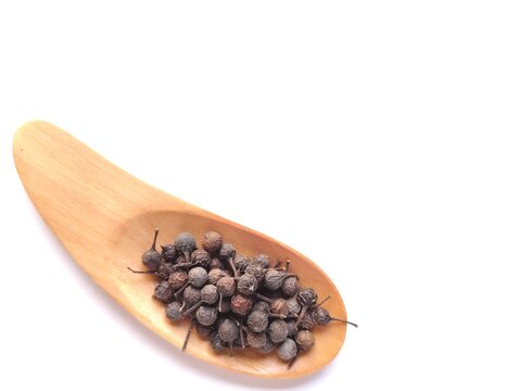 Dried Cubeb Pepper Piper Cubeba Java Pepper on Wooden Spoon with Copy Space Isolated on White Background