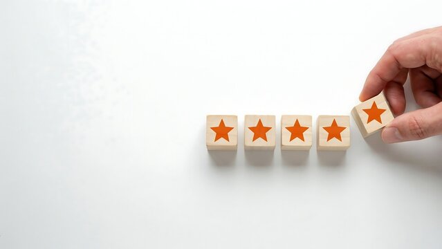 A hand places a star rating block on a table with four blocks.
