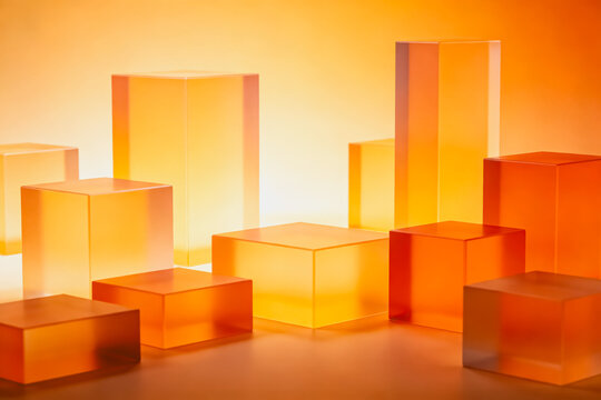 A collection of translucent orange geometric cubes arranged on a warm gradient background, showcasing modern 3D forms and clean aesthetic.