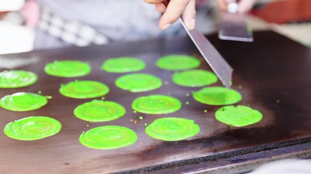 Street Vendor Preparing Green Thai Roti Sai Mai Pancakes on Griddle