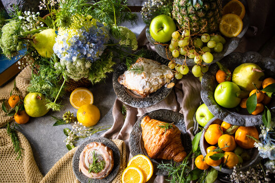 Elegant gourmet breakfast still life featuring fresh fruits, pastries, and rustic tableware arranged in a luxurious artistic composition