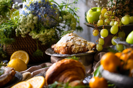 Elegant gourmet breakfast still life featuring fresh fruits, pastries, and rustic tableware arranged in a luxurious artistic composition