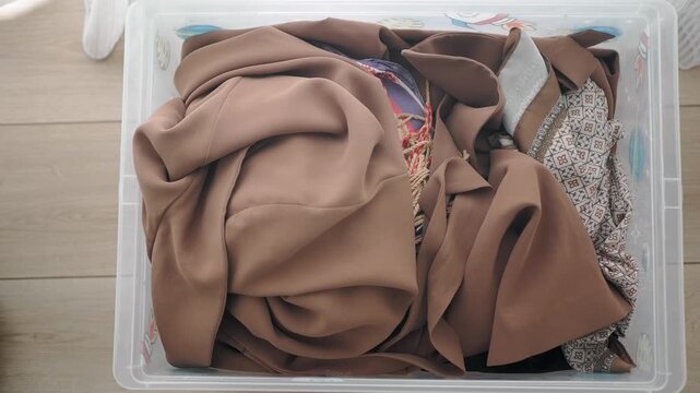 Clothing stored in a clear plastic box at home