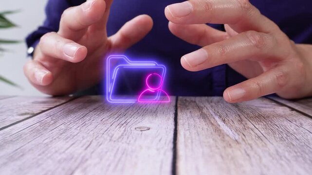A person gestures on a wooden table. A virtual folder icon appears with a user in their hands. This shows interaction with a digital file. 