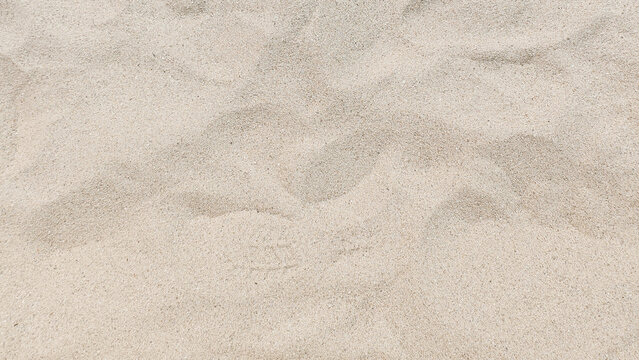 Natural beige sand background on the beach. Summer vacation and tropical travel concept.