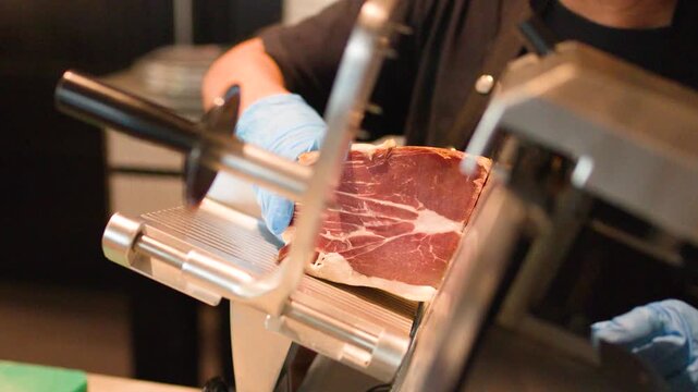Professional Chef Slicing Cured Meat with Electric Deli Slicer