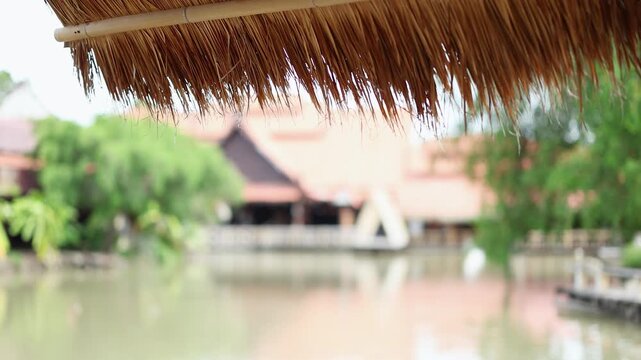 Thatched Roof Overlooking Traditional Thai Village and River Canal