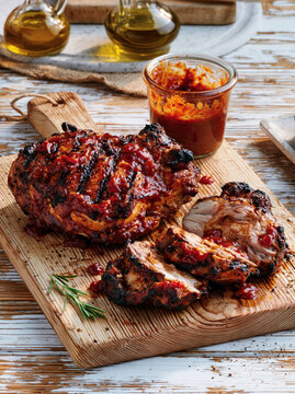 Grilled Barbecue Chicken with Spicy Sauce on Wooden Board. AI generative.