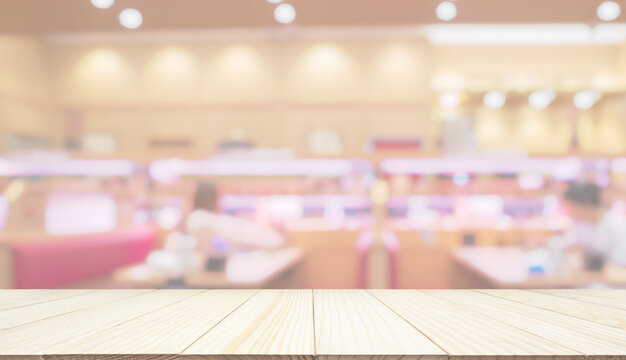 Empty wood table top with cafe restaurant interior blur background