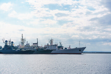 Fototapeta premium Ships of russian navy are on dock on water against background of sky