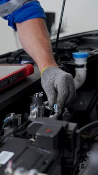 Close-Up Of Mechanic Hand Repairing Electric Vehicle Engine Component