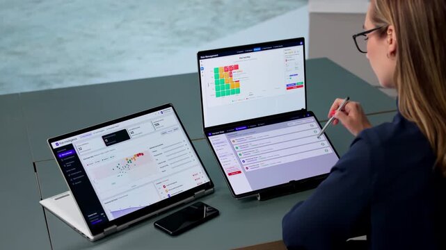 Risk Manager Analyzes Compliance Data On Dual-screen Laptop