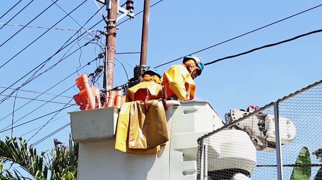 Electrical Utility Workers Performing Single Phase Distribution Transformer Maintenance with Full Safety Equipment
