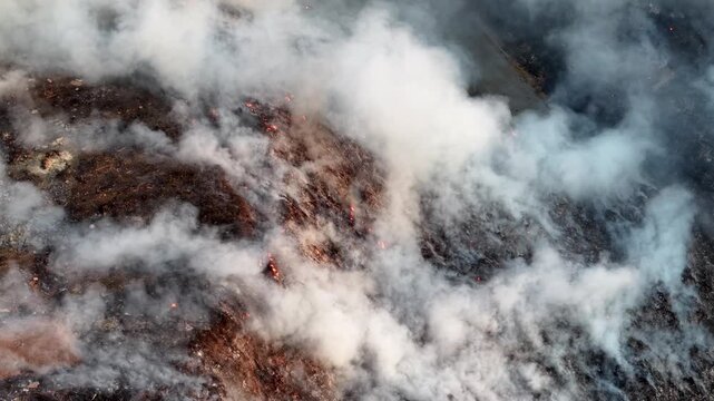 Aerial drone view of fire burning at landfill site